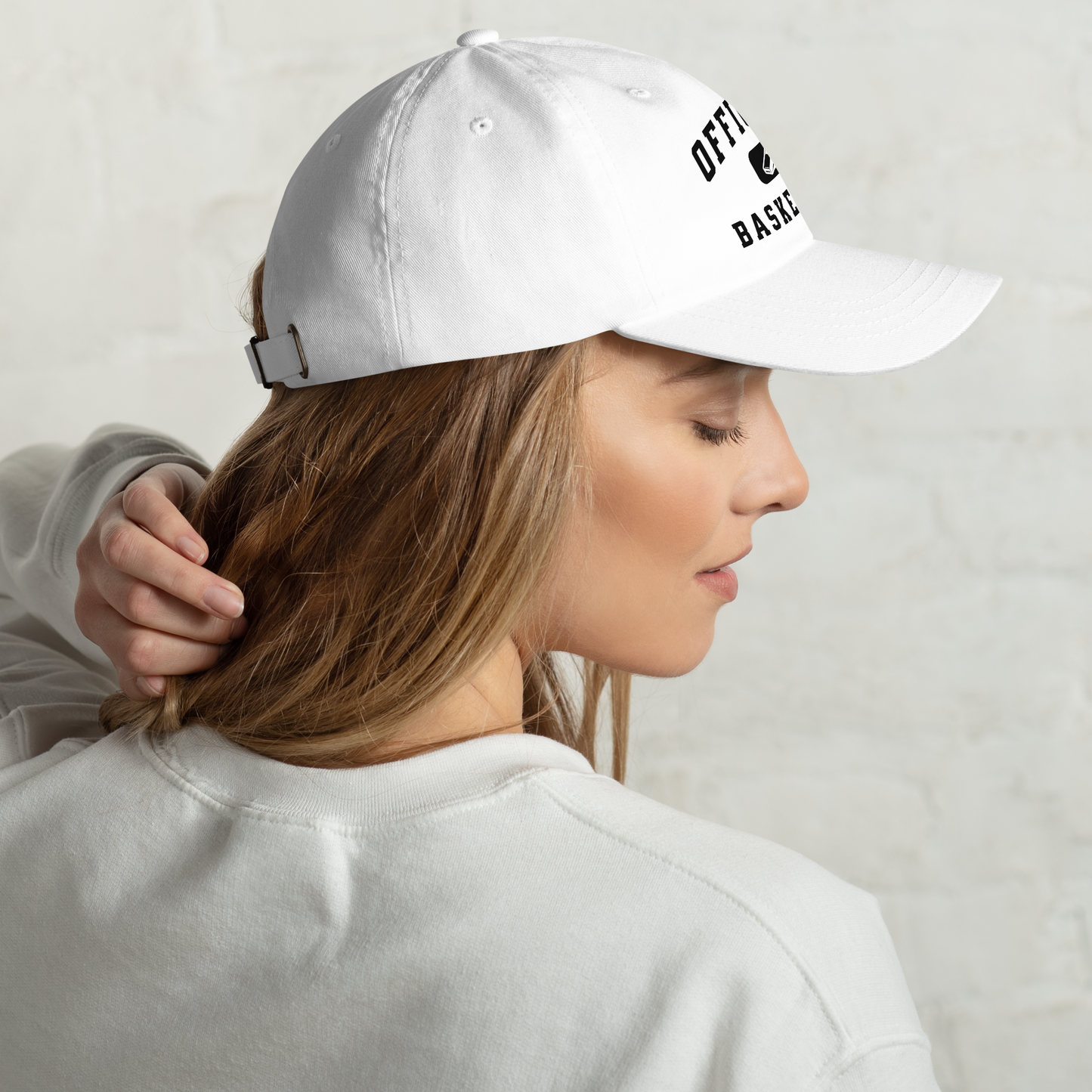 White chino cotton twill dad cap with "Officials Basketball" text and whistle graphic, worn by a woman.