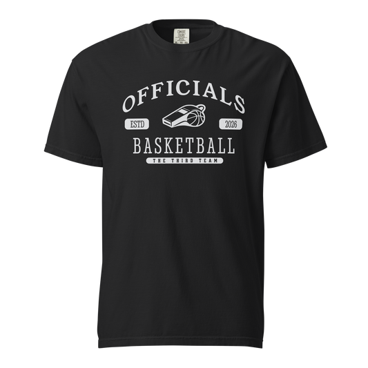 Black garment-dyed heavyweight tee, front view — OFFICIALS arched in white collegiate caps over a whistle and basketball, ESTD 2026 in pill badges, BASKETBALL blocked underneath and THE THIRD TEAM at the base