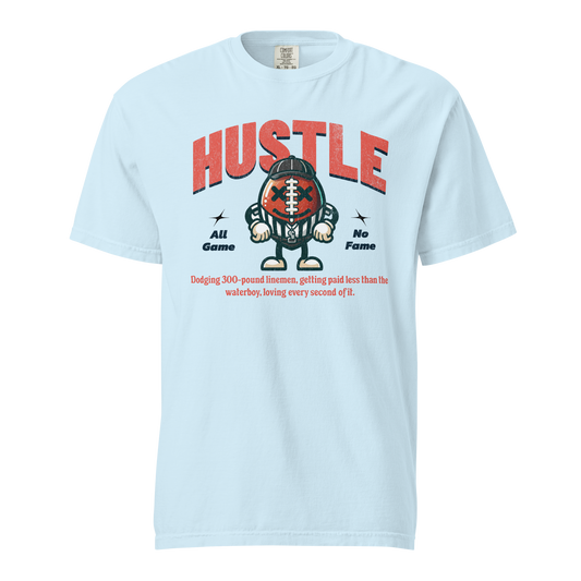 Chambray Ref' Crew All Game No Fame Football Edition tee, retro cartoon football-headed referee mascot in stripes under a distressed HUSTLE arch — front view