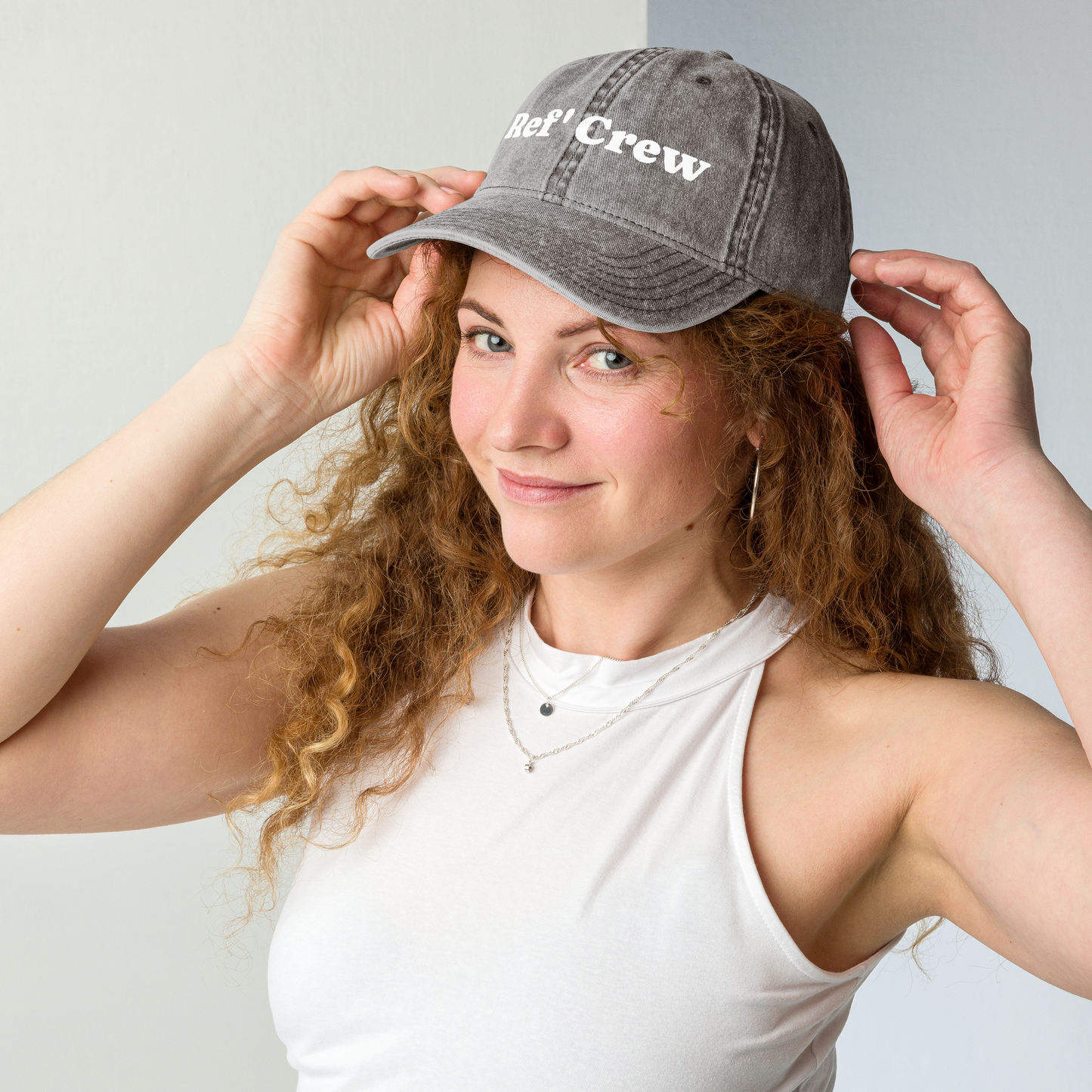 Woman wearing a charcoal gray Ref' Crew vintage washed cotton dad cap with white groovy serif lettering.