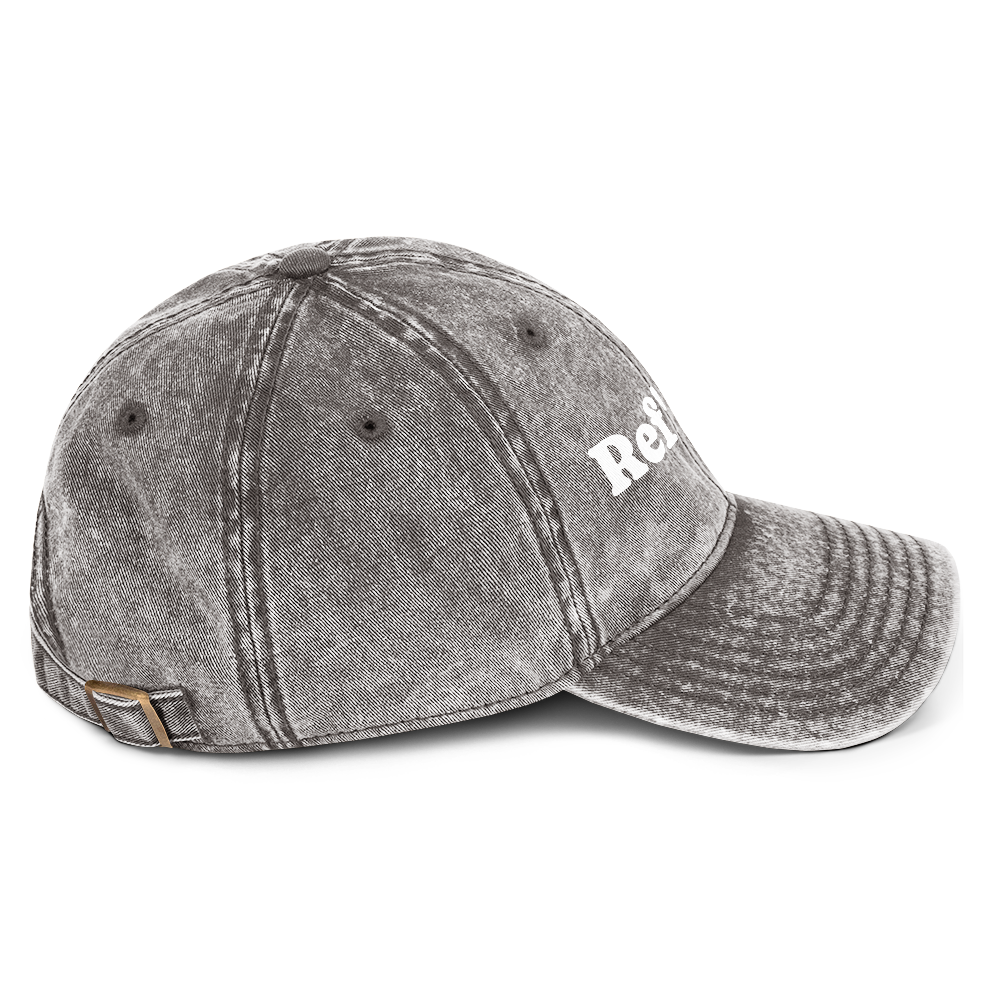 Charcoal gray washed cotton dad cap with "Ref' Crew" in white groovy serif text and brass buckle.